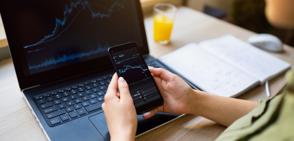 Person holding phone with laptop in background, both with the same data.